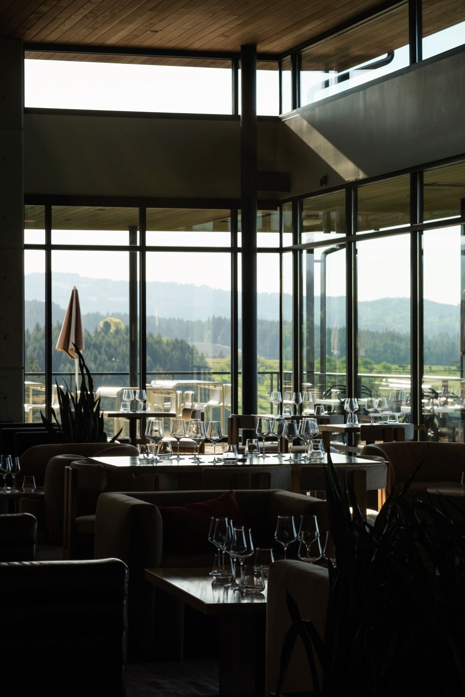 Modern restaurant interior with large windows overlooking a scenic landscape